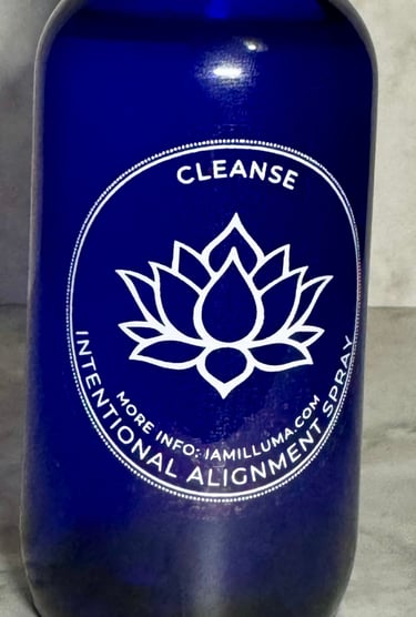 a vibrant blue glass spray bottle with a white lotus label on the front that says Cleanse