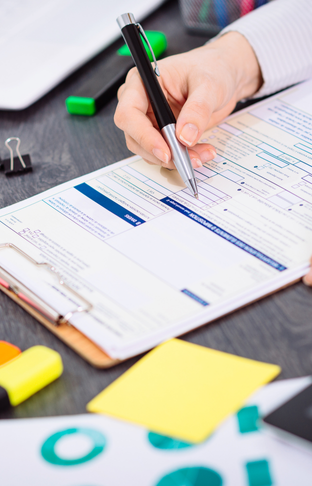 Personne remplissant un document sur une table