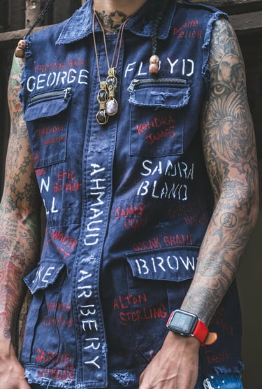 a man with tattoos on his arm and a watch on his wrist