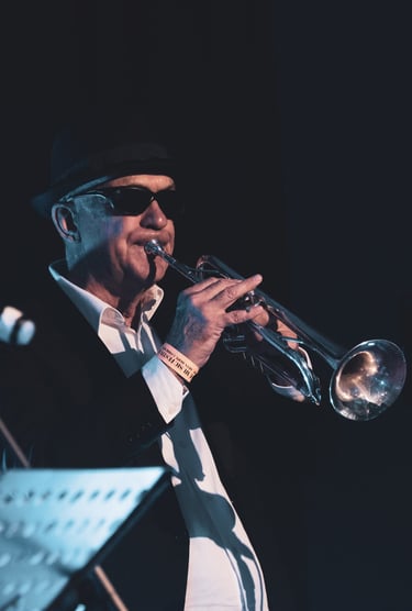 a man in a suit and hat playing trumpet