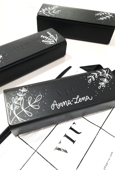 Custom black VIU eyewear cases featuring personalized hand-painted floral art and calligraphy.