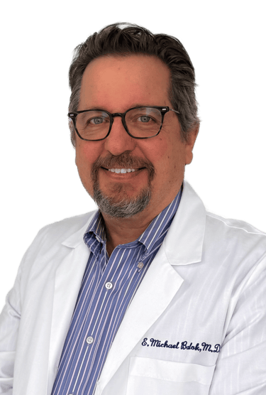 man wearing glasses in a white coat and dress shirt