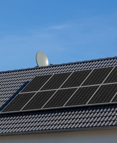 a solar paneled roof with a satellite dish dish on top of a house