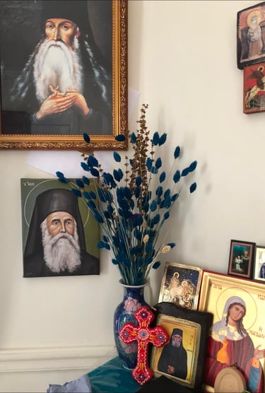 Coin prière de la maison de Berdiaev avec icônes orthodoxes, portrait de saint et vase de fleurs.
