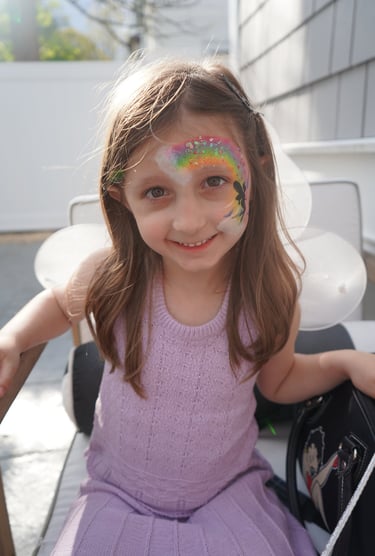 Showing off her rainbow face paint