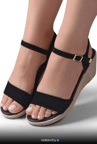 a woman's feet wearing a pair of black sandals
