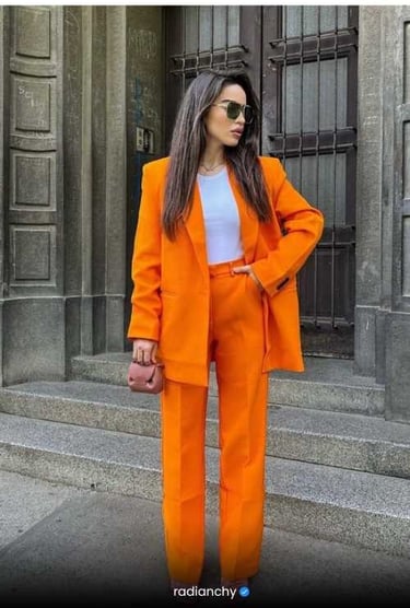a woman in a bright orange suit and sunglasses