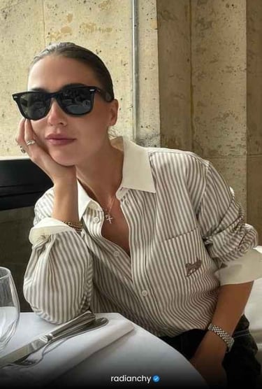 a woman in sunglasses and sunglasses sitting at a table