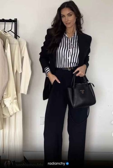 a woman in a black suit and striped shirt