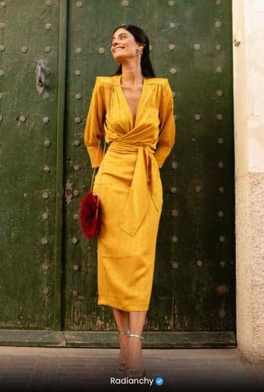 a woman in a yellow dress standing in front of a green door