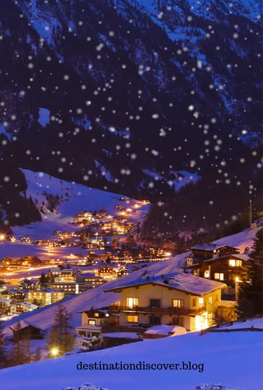 Starry night sky over the Austrian Alps. A charming ski resort village twinkling with lights in the