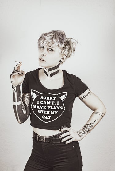 a woman with tattoos on her arm and throat posing for a photo