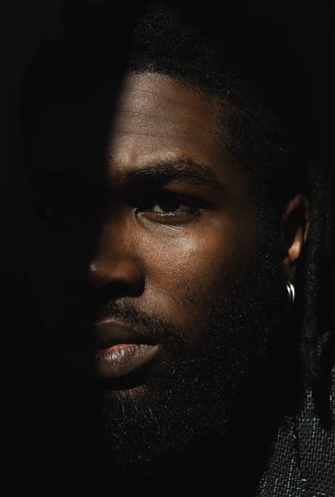 a man with a beard half face in shadow half in the light