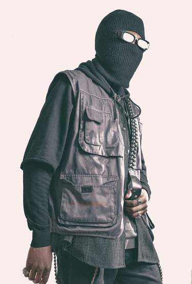 a man in a black jacket and a mask on posing for a photo