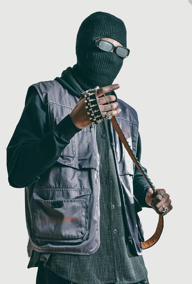 Studio shooting of a man in a black jacket and a mask and holding a belt