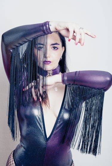 a woman in a violet fantasy suit with afringes