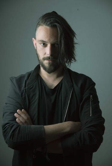 a man with a beard, hair side cut. standing frontale