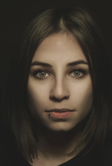 a woman with piercings on her nose and lip, green eyes