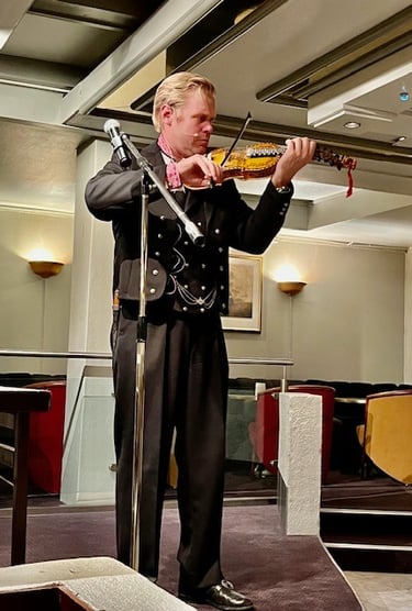 A man in black bunad playing a hardanger violin