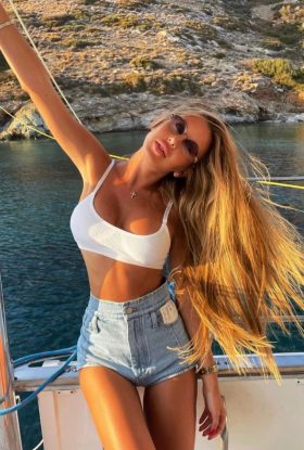 a woman in a white top and shorts on a boat