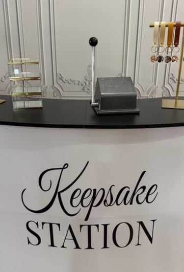 Custom keepsake station booth featuring personalized leather keychains and a photo punching machine.
