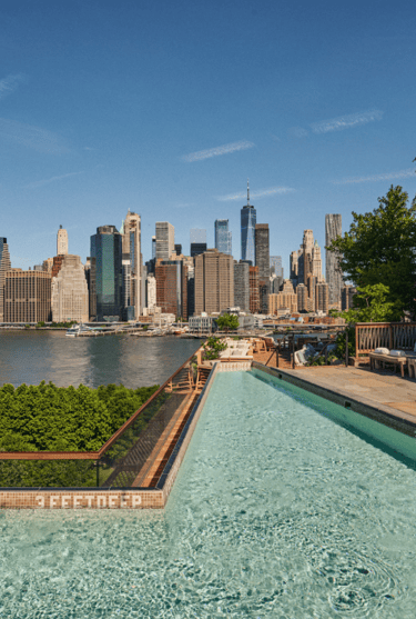 Rooftop pool with skyline view of Lower Manhattan in New York City, ideal summer stay suggestion.