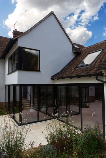 Large sliding doors and glazing creating a modern aesthetic to a home extension.