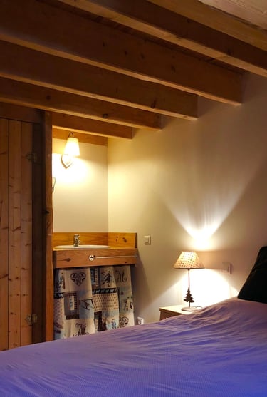 chambre de la grange russell avec un grand lit, un placard et son coin lavabo