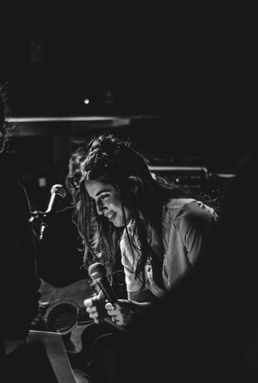 Instant d’émotion d’un chanteur sur scène, saisi en noir et blanc par Thomas Bordas.