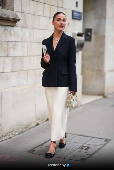 a woman in a black jacket and white skirt