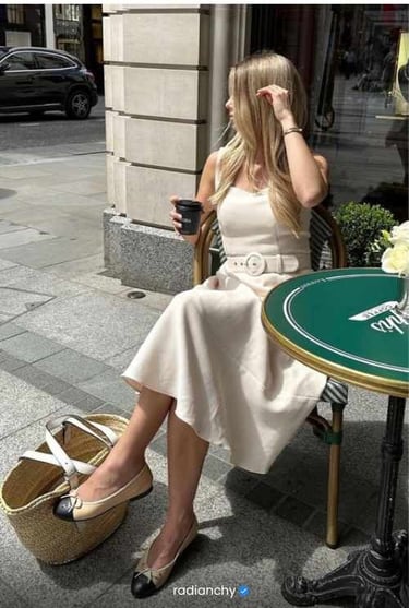 a woman sitting at a table with a cup of coffee