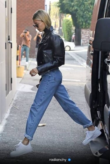 a woman in a black leather jacket and jeans