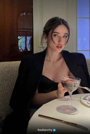 a woman in a black dress sitting at a table