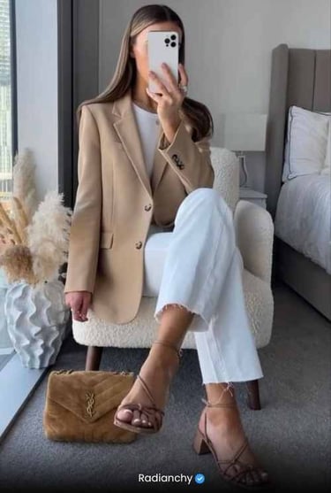 a woman in a tan blazer and white pants