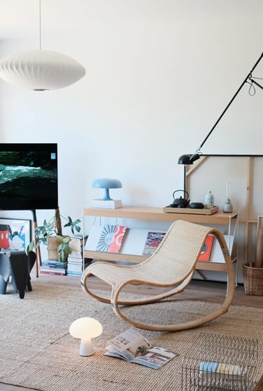 Cozy balcony reading corner with comfortable outdoor chair, small side table, warm lighting, plants,