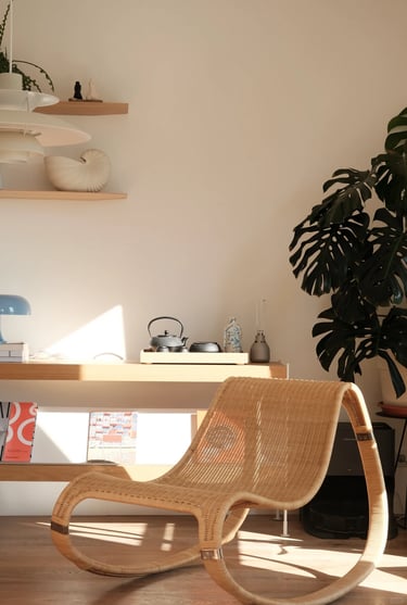 Cozy balcony reading corner with comfortable outdoor chair, small side table, warm lighting, plants,