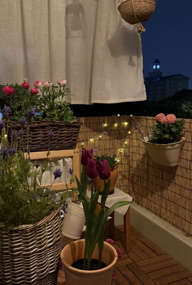 Potted plants placed near a balcony reading corner, creating a soft, private, and natural evening at