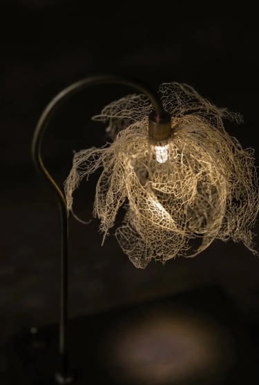 Close-up of a warm leaf-shaped decorative lamp creating soft light for a quiet reading corner.