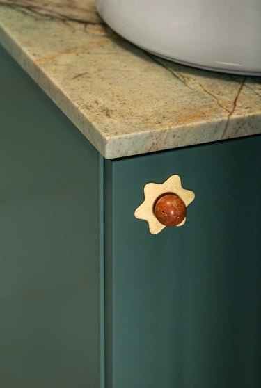 Makrofotografia wnętrz: złoty uchwyt i kamienny blat łazienkowy.