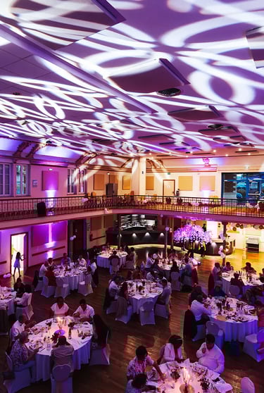 Salle de réception décorée pour le dîner de mariage avec ambiance lumineuse festive.