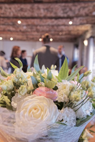 Élégante composition florale de roses blanches et roses lors d'une réception de mariage.