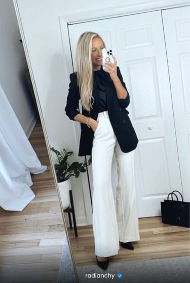 a woman in a black blazer and white pantsuits