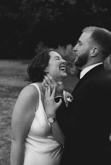 candid black and white photo of a bride and groom laughing