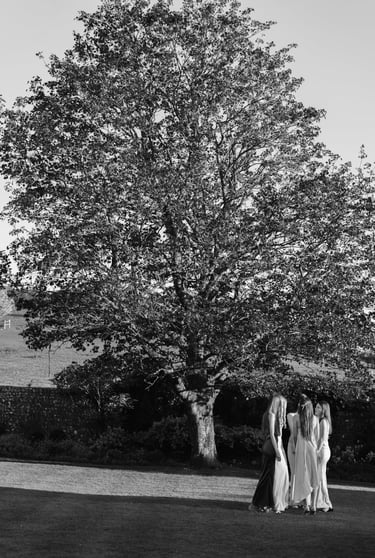 black and white image with group of women and tree in the background