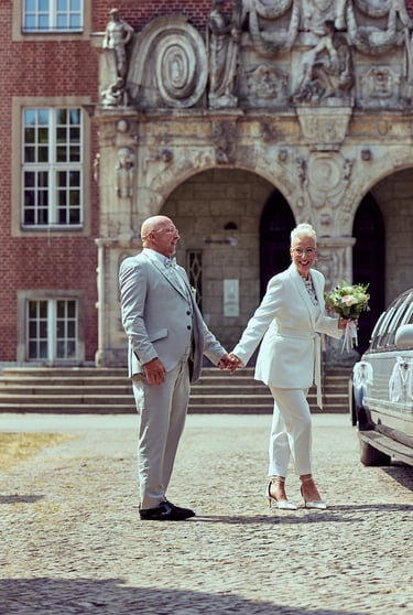 Bride and groom laughing in front of a the Reinickendorf town hall.