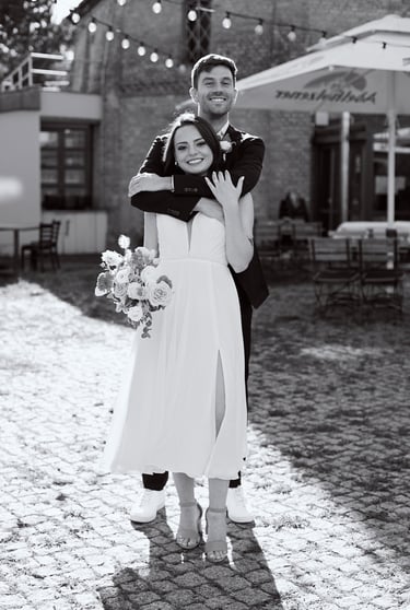 Groom hugging bride from behind.