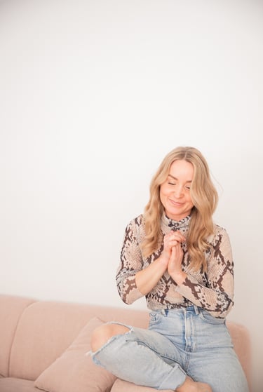 Saija Uussaari sitting on a couch with her hands clasped together