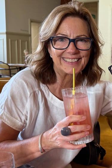 Two adults smiling at restaurant table with drinks and candle, enjoying relaxed social outing