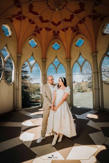 Couple holding hands inside an ornate pavilion in Park, captured by Fred Art Studio.