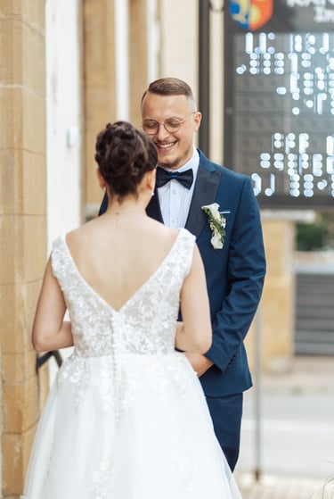Le marié sourit en découvrant sa future épouse de dos lors de leur découverte devant la mairie.